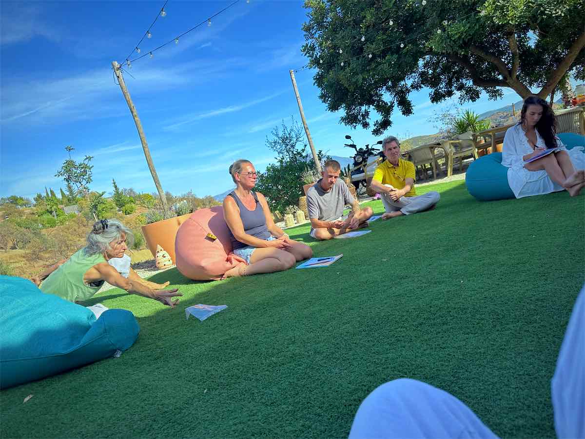 Participants sitting in a circle on the lawn